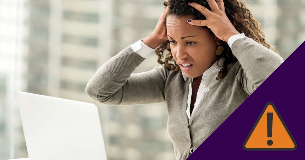 A stressed woman at a laptop with hands on her head next to a warning symbol, illustrating the "follow-through gap" in meetings.
